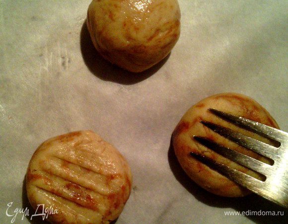 Противень застелить бумагой для выпечки.
От теста отщипывать небольшие кусочки и руками раскатывать шарики.
Уложить на противень на расстоянии друг от друга.
Вилкой немного расплющить шарики.
Поставить в заранее разогретую духовку до 180°C на 15 минут(не больше).
Когда печенье находится в духовке, оно очень мягкое. Как только оно начинает остывать - становится тверже. Снимайте его с противня ещё не остывшим.


