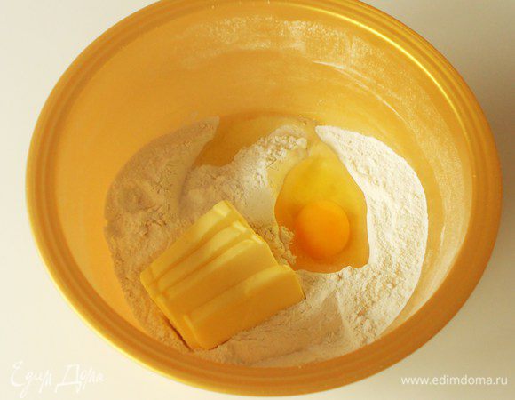 В миске соединить просеянную муку, сахарную пудру, сливочное масло и яйцо.