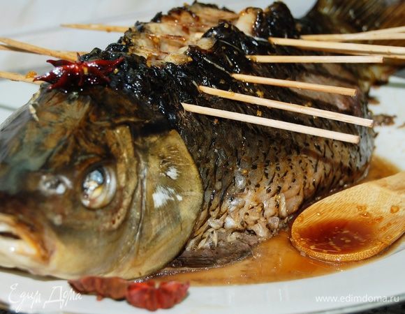 Для соуса растопить в сотейнике сахар и 3 ст.л. воды. Добавить измельченный имбирь, соевый соус, бадьян и уксус. Развести крахмал в 2 ст.л. воды и тонкой струйкой влить в соус. Тщательно перемешать снять с огня. 
Перед подачей извлечь шпажки и кулинарную нить. Облить карпа соусом.
