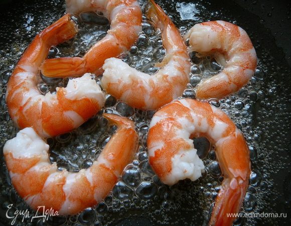 Налить в сковороду оливковое масло и обжарить креветки по 2 минуты с каждой стороны.