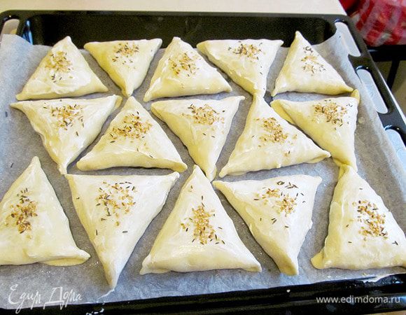 Выложить самсу на противень. Смазать яйцом или сметаной (как у меня) посыпать кунжутом, зирой. Выпекать до готовности в духовке, минут 30.
Готовую самсу смазать сливочным маслом, сложить в емкость и плотно накрыть. Дать ей запариться минут 30. Она станет мягкой, душистой.