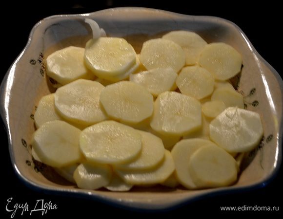 Порежем пластинками картофель и лук. Выложим слоями в жаропрочное блюдо часть.
