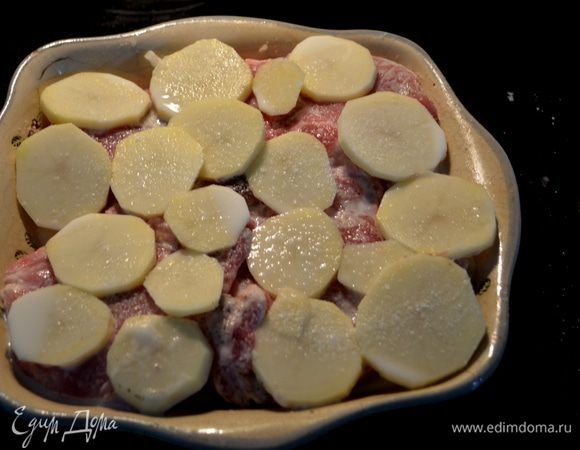 Свиные отбивные припылим мукой и обжарим на сковороде на олив.масле слегка  с обеих сторон. Выложим поверх картофеля. Выльем в сковороду молоко после обжарки свиных отбивных,смешаем остатки с молоком,а затем тут же в блюдо с картофелем и отбивными.Поверх выложим оставшийся картофель.