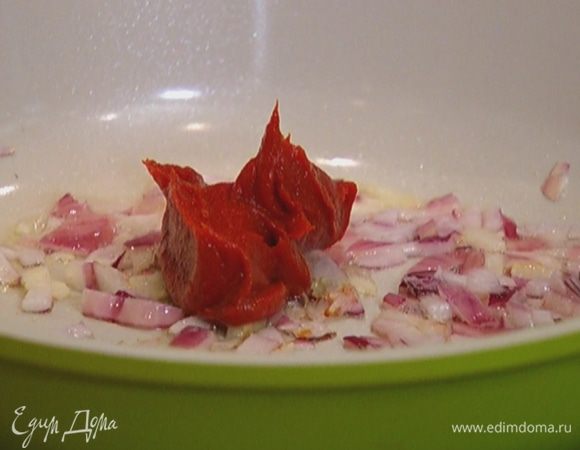 Разогреть в сковороде 1 ст. ложку оливкового масла и обжарить лук и чеснок на небольшом огне, затем добавить томатную пасту, лавровые листья и чили, все перемешать и немного прогреть.