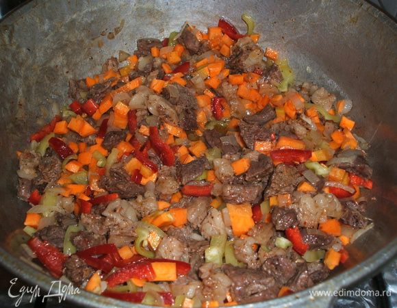 Пока мясо жарится, подготовьте овощи: лук, морковь, болгарский перец помойте, очистите и нарежьте мелкими кусочками, т. е. кубиками. Болгарский перец можно нарезать покрупней. Постепенно добавьте в казан, где уже поджарилось мясо, лук (его надо обжарить 2–3 минуты), затем морковь и перец.