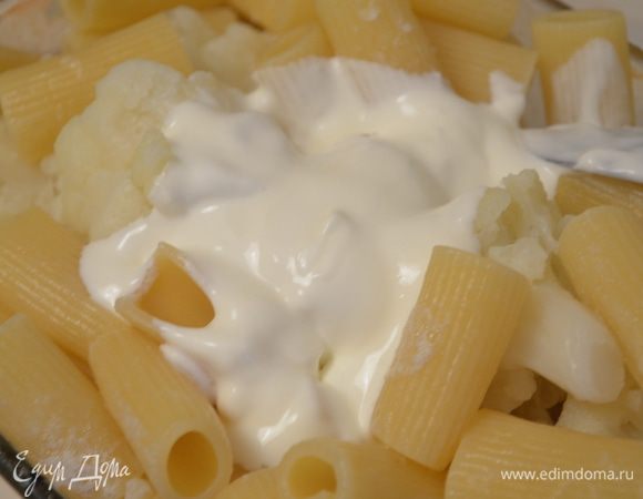 Добавляем 1 горсть тертого сыра, слитую воду, сметану, муку, солим и посыпаем розмарином. Все перемешиваем. 