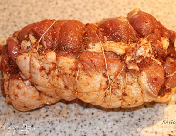 Выкладываем на подготовленное мясо томатно-чесночную смесь и равномерно распределяем по поверхности. Плотно сворачиваем мясо в рулет. Связываем кулинарной нитью или шпагатом. (Здесь уместно к процессу привлечь мужа:)) Смазываем рулет сверху оливковым маслом. Я смазала маслом из-под томатов.