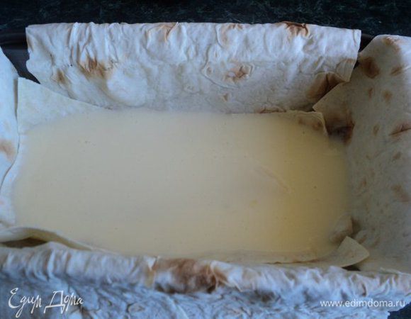 Форму смазать маслом, выложить вырезанный лист лаваша, на дно положить второй слой лаваща (из обрезков). Налить на дно немного заливки.