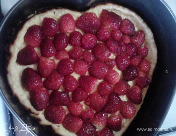 Достаньте торт из духовки, остудите его и выложите на него клубничке, разрезав каждую пополам.