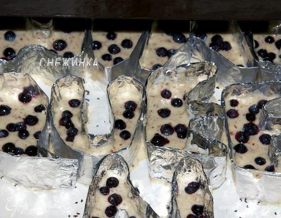 Устанавливаем их на противень, который я предварительно слегка смазала маслом и присыпала манкой. Теперь кладем тесто в наши «формочки», где-то наполовину. Сверху на тесто рассыпаем чернику.
