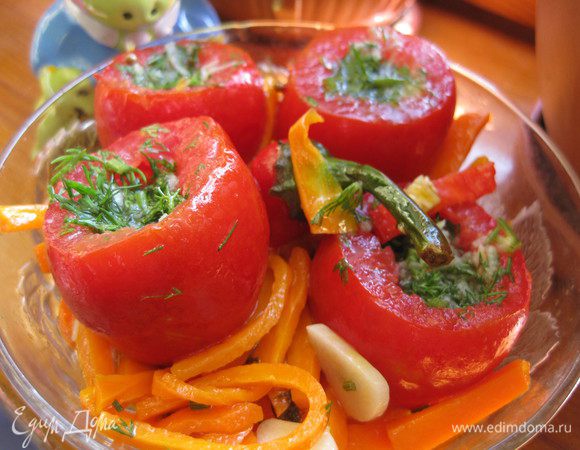 Готовим маринад. Соль и сахар расстворяем в воде, доводим до кипения и добавляем уксус.
Морковь режем брусочками и обжариваем под крышкой с 150 мл растительного масла, солим,  добавляем коринадр и 1 головку чеснока (режем на пластины). Готовим до полуготовности моркови, чтобы слегка хрустела.
Готовим начинку для помидор, мелко шинкуем укроп с 1 головкой чеснока.