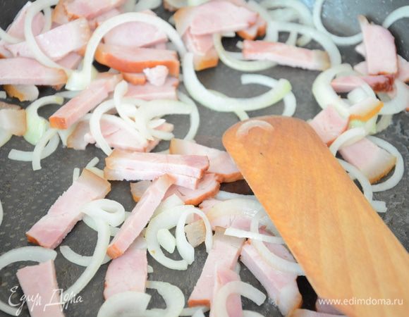 Лук нарезать полукольцами,бекон соломкой.Обжарить на на растительном масле. 