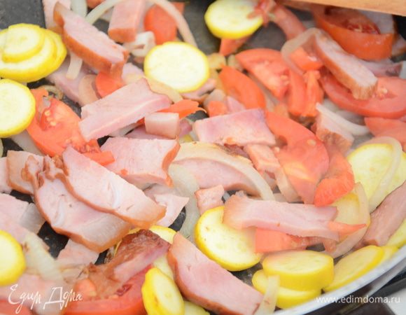 Помидоры порезать и добавить на сковороду,так же поступить с кабачком.Затем добавить рубленный чеснок.