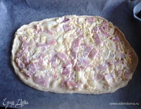 Тесто делим на 4 равные части. Берем одну часть, раскатываем и переносим ее на противень застеленный бумагой для выпечки, делаем у теста небольшие края. Выкладываем на тесто начинку и ставим в духовку, разогретую до максимума, на 10 минут