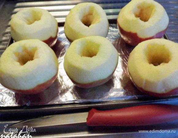 Разогрейте духовку. Маленький противень (у меня размером 25 на 15 см) застелите фольгой. Яблоки вымойте и обсушите бумажным полотенцем. Аккуратно ножом удалите сердцевину, но не насквозь, а оставив дно целым. У верхушки яблока овощечисткой срежьте по спирали 2 витка яблочной кожуры.