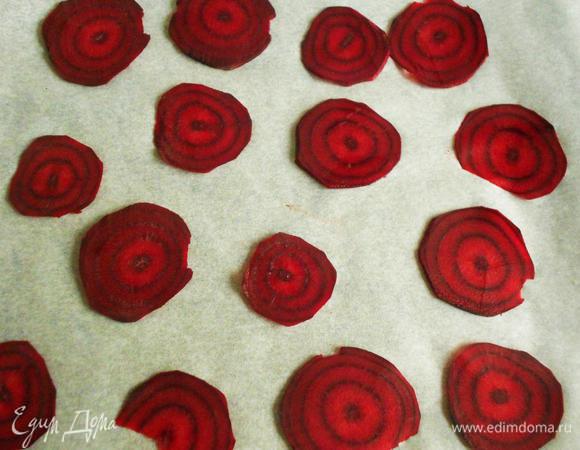 Снизить t в духовке до 120*С.
 Помыть и очистить свеклу, нарезать очень тонко. Поместить кружочки на противень с бумагой для выпечки от "HQC"  и поставить в духовку. Возможно, один-два раза придётся их переворачивать, чтобы ускорить подсушивание. Нужны хрустящие пластины со слегка загнутыми краями. В  конце приправьте их солью и молотым перцем.