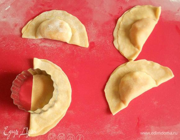 Свернуть тесто вдвое в виде половинки Луны . Смазать яйцом свободный край и прижать пальцами для прочного склеивания сторон. Круглой формочкой (тупой стороной) или стаканом подходящего диаметра обжать начинку. Сильно не давить, тесто не прорезать! Только плотно скрепить.