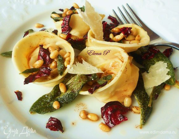 Вынуть тортеллини шумовкой на тарелки (без воды!).  Полить маслом с орешками, выложить лепестки  пармезана и сразу же подавать.