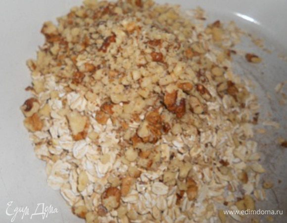 В мисочке смешать хлопья и измельченные грецкие орехи, добавить соду, сахар, молоко и масло, перемешать и добавить муку. Получится тесто в виде мягкой крошки.