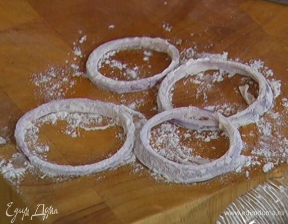 Налить в пиалу молоко, в другую пиалу насыпать муку с солью и перцем. Опустить луковые кольца в муку, затем в молоко и снова обвалять в муке.