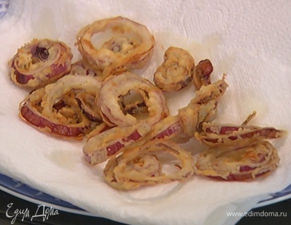 Обжарить луковые кольца во фритюре и выложить на бумажное полотенце, чтобы убрать излишки жира.