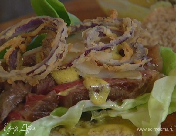 Ржаные булки разрезать пополам вдоль, смазать одну половинку горчичной заправкой, выложить салатный лист, затем кусочки мяса, сверху еще немного смазать заправкой, добавить хлопья пармезана, луковые кольца и накрыть верхней половинкой булки.