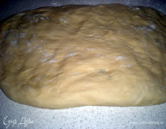 Поднявшееся тесто выкладываем на стол. Расправляем руками, формируя прямоугольник.