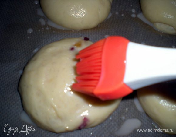 После расстойки булочки обильно смазать глазурью. На глазурь по желанию можно насыпать сахар или миндальные лепестки. Выпекать в разогретой до 180°C духовке 20–25 минут. 