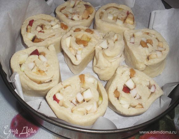 Выложите в круглую форму, застеленную пергаментной бумагой срезом вверх. Между улитками оставляете место, так как тесто будет расти. По желанию, посыпаем сахаром улитку.