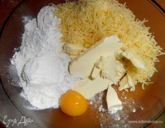 Высыпаем сыр к тесту и вымешиваем руками,подсыпая муку...