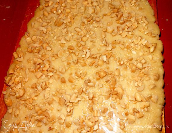 Густо посыпаем ими пласт теста.Если орешки не солёные,то можно присыпать крупной солью.