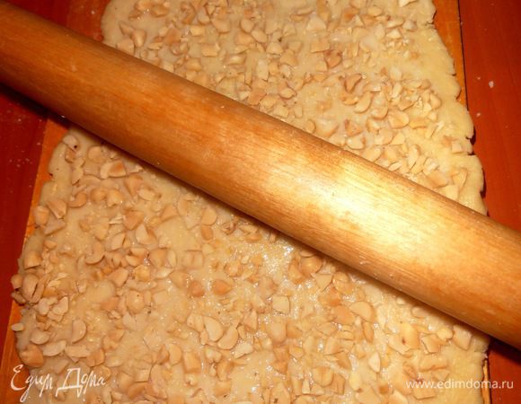 Теперь пригладим скалкой орехи,слегка утопив их в тесто!
