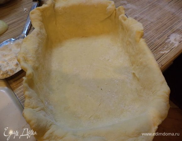 Тесто разделите на 2 неравные части. Большую раскатайте и уложите в форму, смазанную маслом, так, чтобы остались бортики.