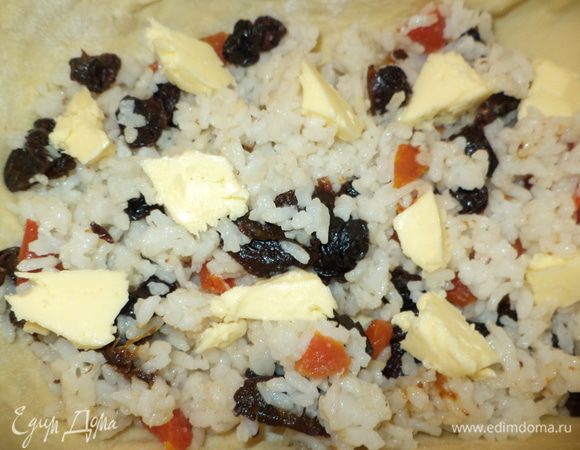 Первый слой: рис с сухофруктами, сверху — небольшие кусочки масла. 