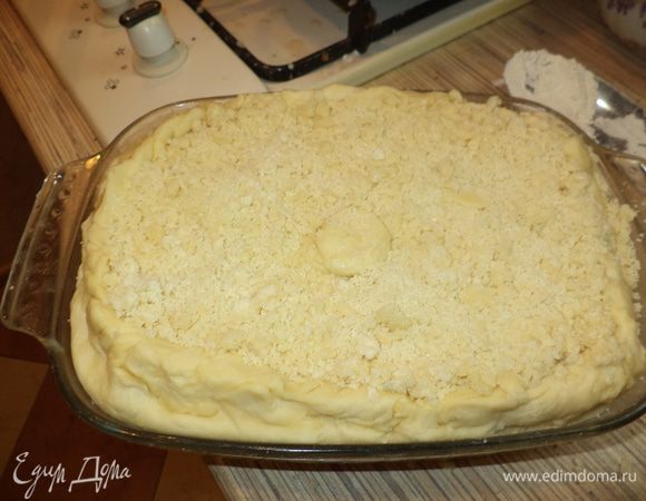 Смажьте пирог молоком и посыпьте крошкой. Поставьте в духовку на 180°C на 30–40 минут до образования золотистого цвета.