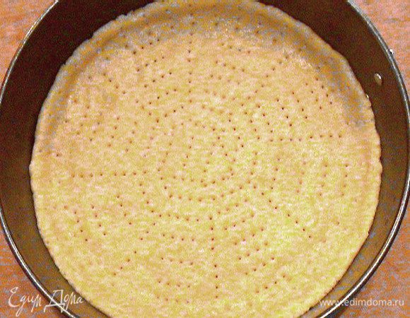 Положить в глубокую миску все ингредиенты для теста и хорошо вымесить. Получится мягкое эластичное тесто, не липнущее к рукам.
Постелить на дно формы бумагу для выпечки и выложить на него равномерным слоем тесто, сделав небольшие бортики по краям (1-2см). Сделать наколы вилкой и поставить в разогретую до 175 градусов духовку на 10 минут.
