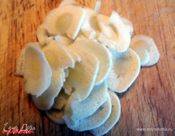 Чеснок почистить, помыть и обсушить бумажным полотенцем. Пошинковать его вдоль на тонкие "лепестки". Разложить "лепестки" сверху и между кусочками помидор. 