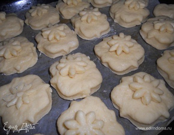 тесто разделить на двое,раскатать сначала одну часть не тонко толщина пласта  6-7 мм и вырезать формой или стаканом одинаковые булочки,затем второй кусок теста раскатать и вырезать булочки,из остатков теста можно сделать цветочки украшения,а можно подмесить остатки и раскатать и также вырезать еще булочки,сложить буложки на застеленый пергаментом противень