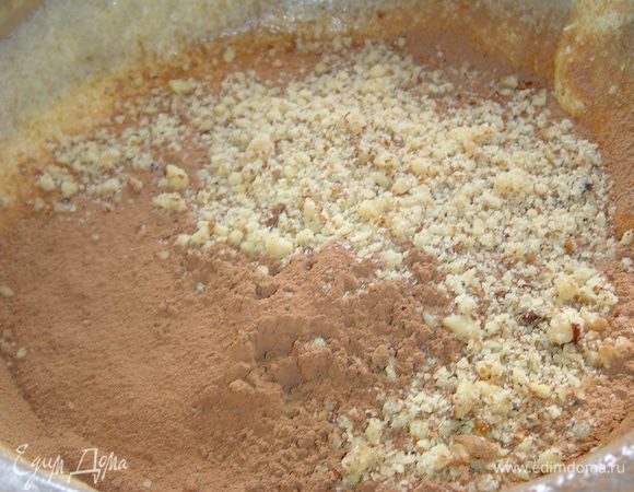 Эту массу делим на две равные части и к одной из них добавляем какао, измельченные орехи, перемешиваем.