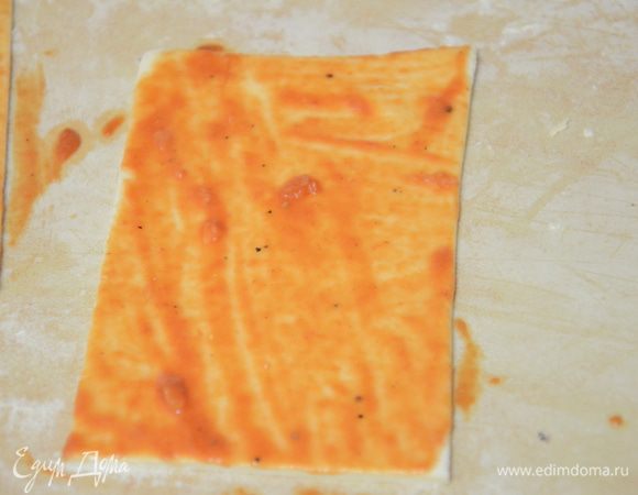 Тесто раскатать на присыпанной мукой поверхности.Разрезать на прямоугольники размером примерно 4 см на 10 см. Томат пасту посолить,поперчить,добавить мелко рубленный чеснок (зубчик), сухую зелень базилика.