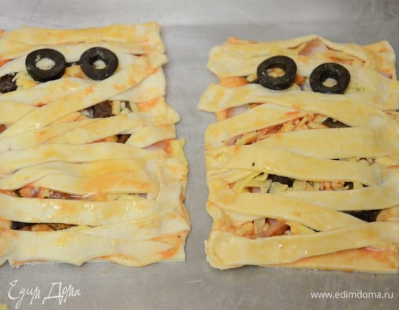 Маслины тонко нарезать и выложить два колечка маслин в виде глаз.Поставить запекаться в заранее разогретую духовку до 180С на 15-20 минут. 