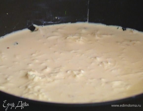 Вынуть из морозилки охлажденный корж и выложить на него сырную начинку.