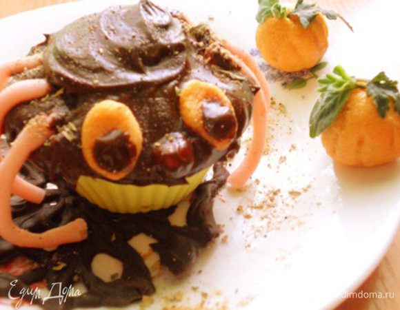 достать из духовки и остудить,украсить так:шоколад растопить с маслом и перемешать,смазать им вверх кекса,из розовой мастики сделать лапки,из оранжевой сделать глазки и носик,ножки приделать к кексу,на глазки сделать капельки из шоколада,носик обмакнуть в шоколад,все приделать к паучку,потом из оранжевой мастики сделать два шарика обратной стороной ложки сделать бороздочки так,чтобы были похожи на тыковки,сверху украсить листочками