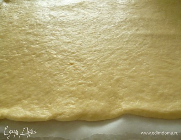 Берем лист бумаги для выпечки,отмеряем его по размеру формы(включая высоту бортика),смазываем бумагу растительным маслом.Раскатываем тесто на листе бумаги.