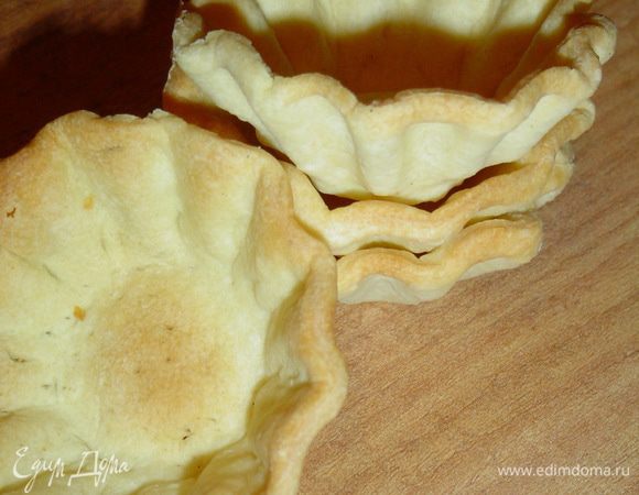 Готовое слоеное тесто раскатываем, стаканом вырезаем кружочки, распределяем их в смазанные маслом формочки и выпекаем при температуре 180 гр. до золотистого цвета.