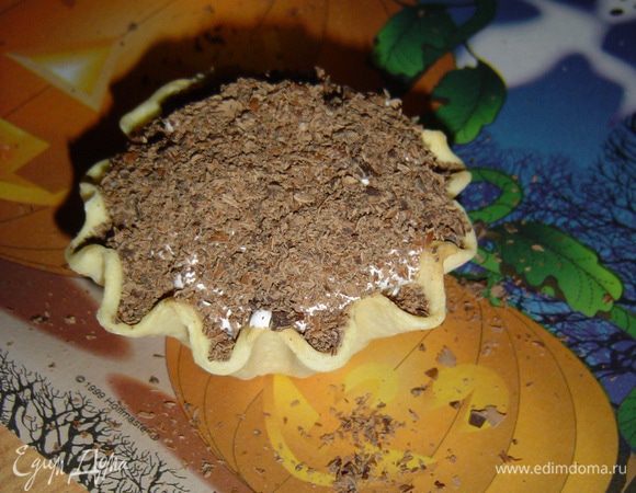 Охлажденный черный шоколад натираем на терке и посыпаем сверху крем.