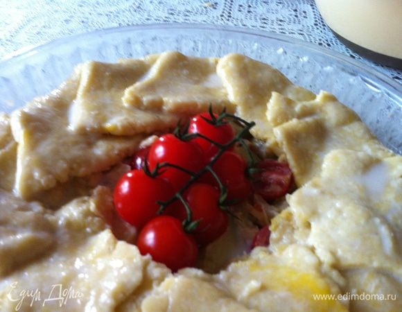 Заворачиваем края. В центр кладем веточку томатов черри. Поставить пирог в холодильник на 20 мин. Достав из холодильника, поверхность теста смазываем смесью сливок и слегка взбитого белка.