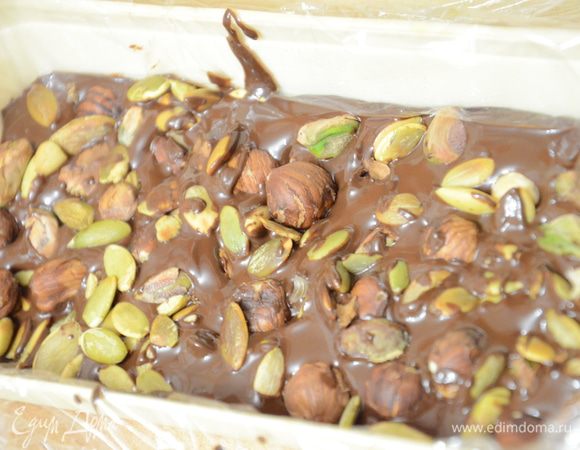 Вылить шоколад растопленный в форму, присыпать орехами и семечками тыквы. Поставить застывать в холодильник.