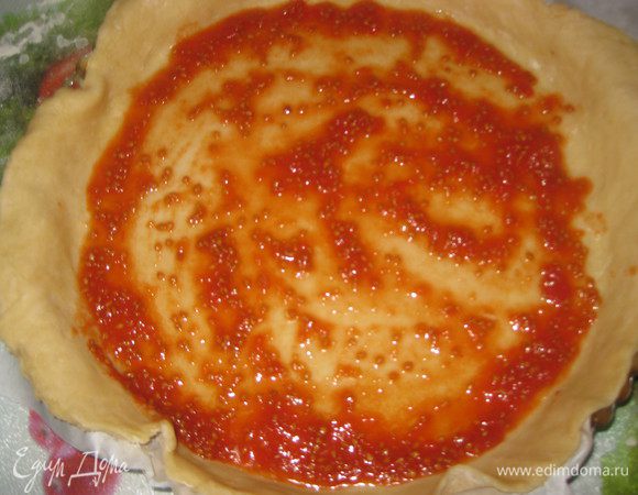 Готовим соус: для этого помидоры измельчаем блендером в пюре, добавляем сахар, соль. Тесто раскатываем в круг диаметром примерно 40 см. Смазываем соусом, оставляя по 5 см теста по краях без соуса