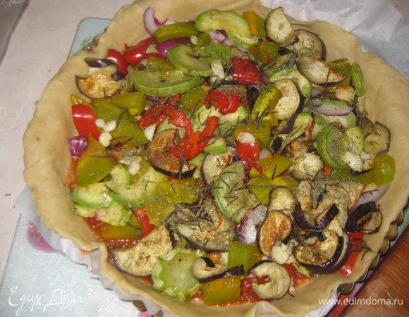 Выкладываем нашу начинку на тесто, оставляя свободными  края, посыпаем порезанным на ломтики чесноком, порезанным полукольцами луком, розмарином и тимьяном,  все перемешиваем.





